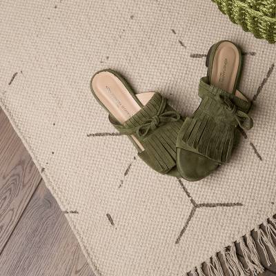 Detailaufnahme Designteppich in creme und grau mit Fransen von heineking24